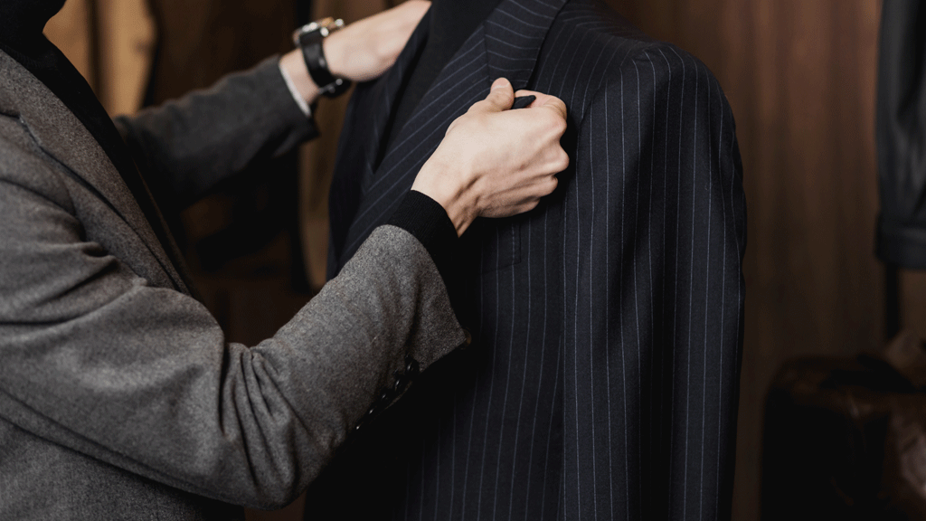 Conseiller showroom présentant costume à client masculin discussion professionnelle